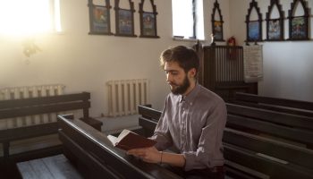 close-up-priest-reading-form-bible