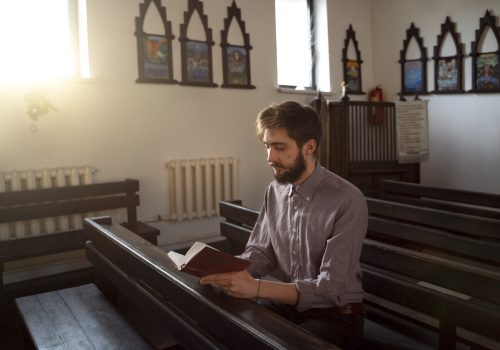 close-up-priest-reading-form-bible